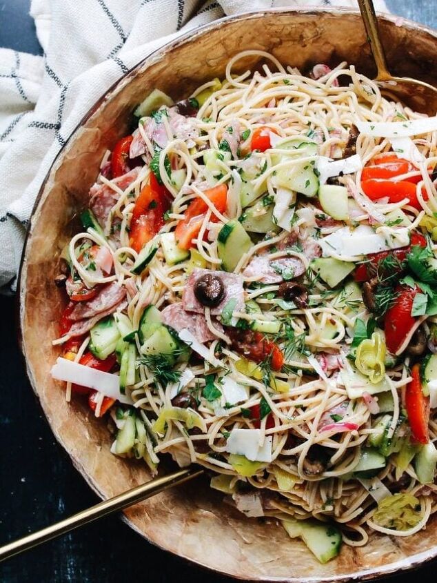 pasta salad with sun dried tomatoes green olives provolone, overhead shot of a bowl of zesty italian pasta salad with cucumbers