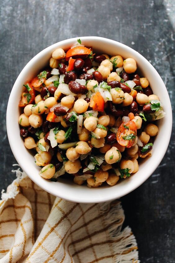 curry chicken salad with grapes, chickpea and black bean salad in a bowl on a dark background