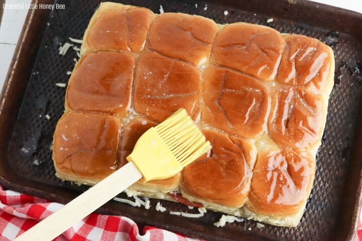pepperoni pizza sliders, Sliders sitting on a baking sheet and slathered with butter