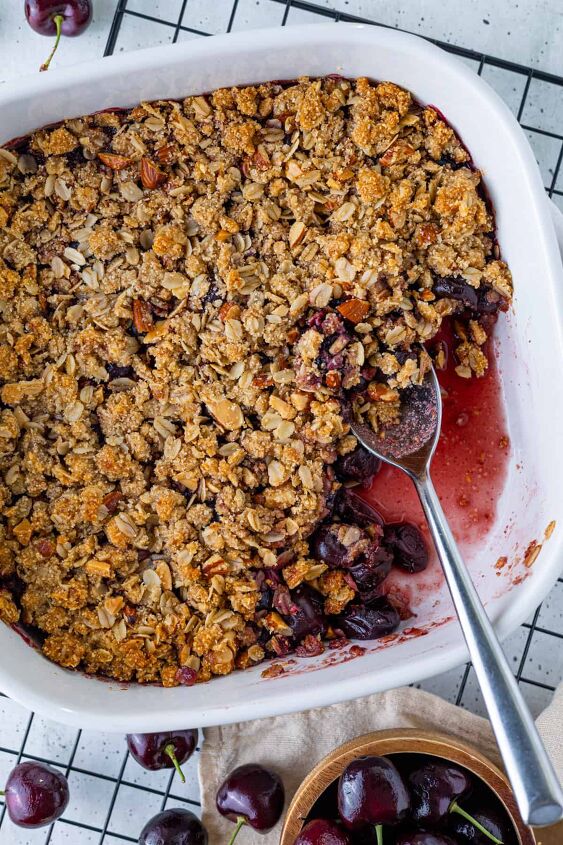 how to make homemade cherry crumble, A pan of cherry crumble with a portion taken out of it