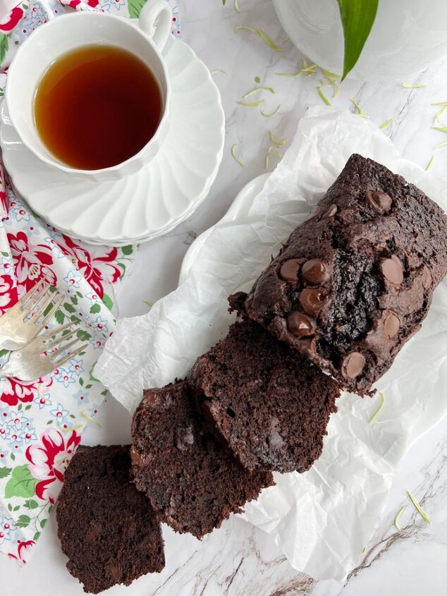 the best double chocolate zucchini bread, Zucchini Bread sliced on a plate with a cup of tea
