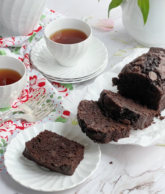 the best double chocolate zucchini bread, chocolate zucchini bread sliced with 2 cups of tea in white china cups
