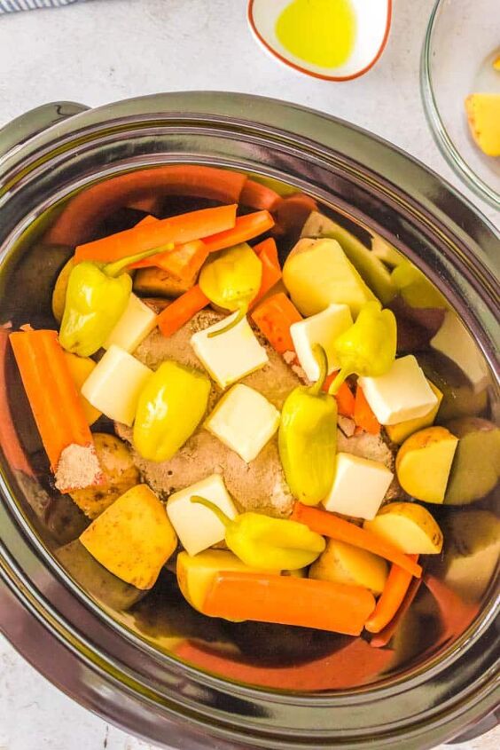 mississippi pot roast with potatoes and carrots crock pot, Veggies butter and seasoning added to the chuck roast to make Mississippi Pot Roast with Potatoes and Carrots in the crockpot