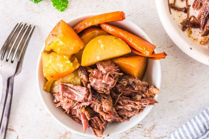 mississippi pot roast with potatoes and carrots crock pot, Mississippi Pot Roast with Potatoes and Carrots in a white bowl with a fork