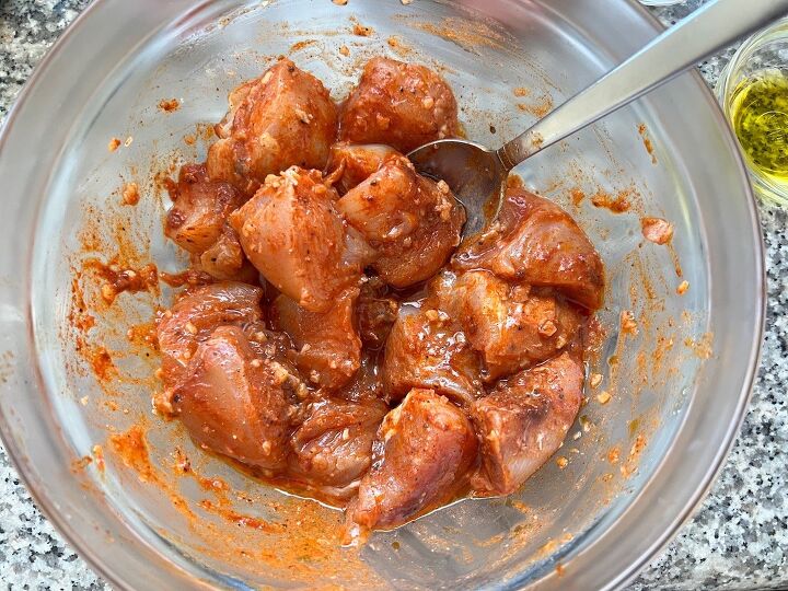 galinhada dutch oven chicken and rice, Raw chicken mixed with paprika and garlic and other marinade ingredients for Galinhada Dutch Oven Chicken and Rice