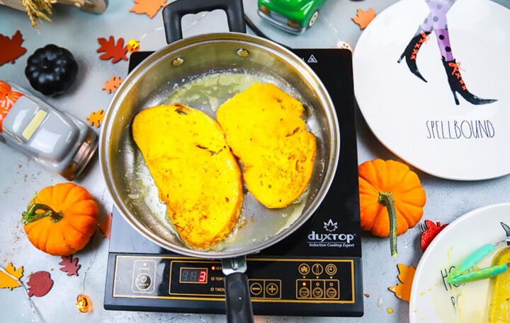 pumpkin brioche french toast, fried french toast in a pan on the stovetop with pumpkins next to it