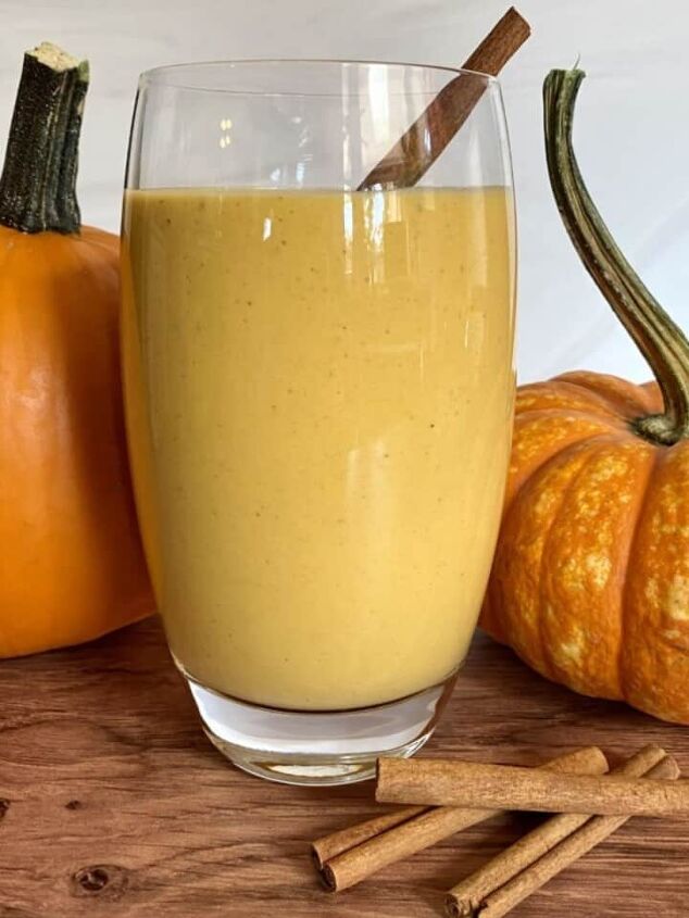 blueberry protein shake, Orange colored pumpkin pie smoothie in a glass with real pumpkins on either side of the glass Cinnamon sticks are next to the glass