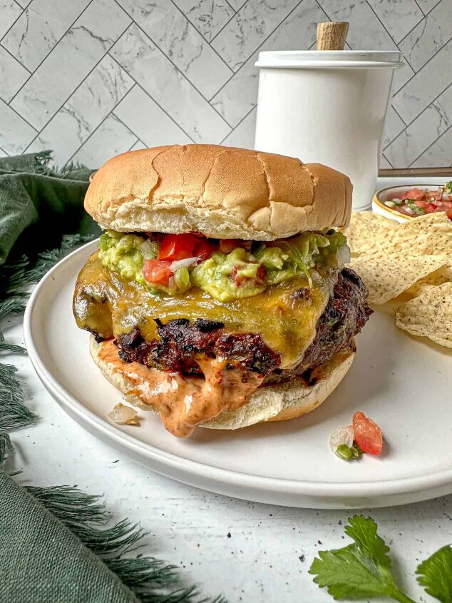 southwest burger with chipotle mayo, Southwest burger with chipotle mayo guacamole and pico de gallo on a white plate with tortilla chips