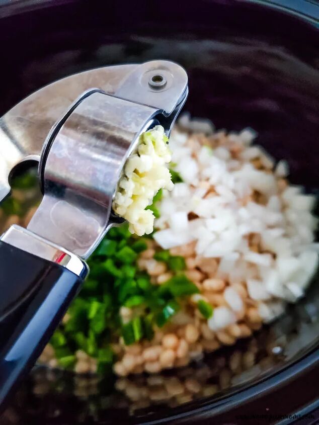slow cooker chicken chili with white beans, garlic being added to crockpot