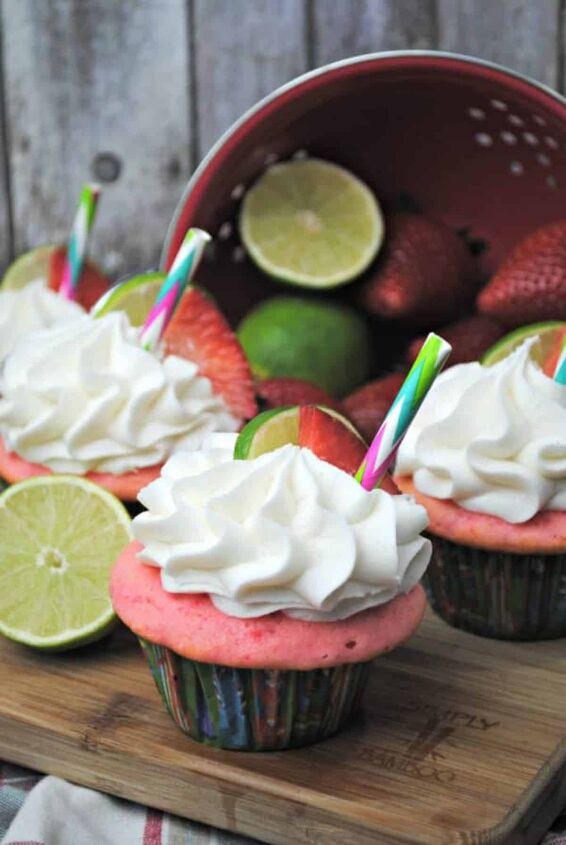 strawberry margarita cupcakes, Strawberry Margarita Cupcakes topped with lime and strawberry and colorful straw on a wooden board