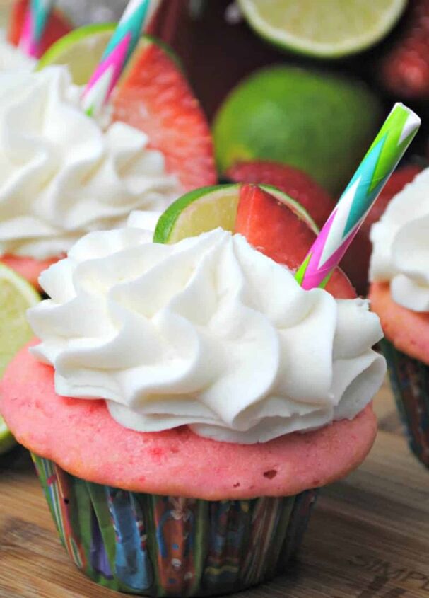 strawberry margarita cupcakes, Strawberry Margarita Cupcakes topped with lime and strawberry and colorful straw on a wooden board
