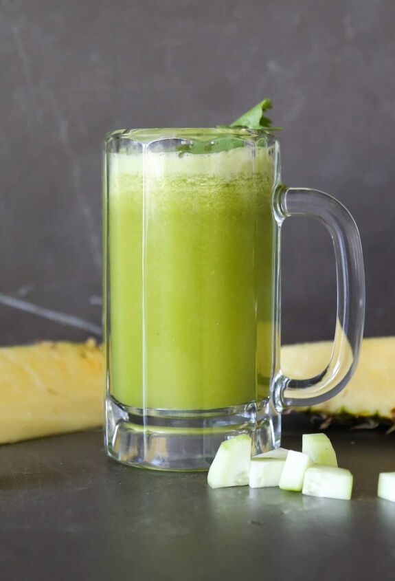 pineapple and cucumber detox juice recipe, Cucumber and pineapple juice in a glass with sliced cucumber and cilantro garnish