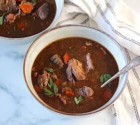 korean beef stew recipe slow cooker or oven, Two bowls of Korean Beef Stew one with a spoon on counter with blue and white striped towel Korean Beef Stew is sweet salty tangy and oh so flavorful