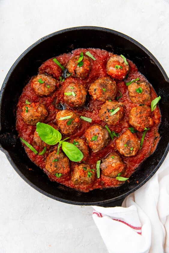 easy keto cast iron meatballs, cooked keto meatballs in a keto spaghetti sauce topped with basil
