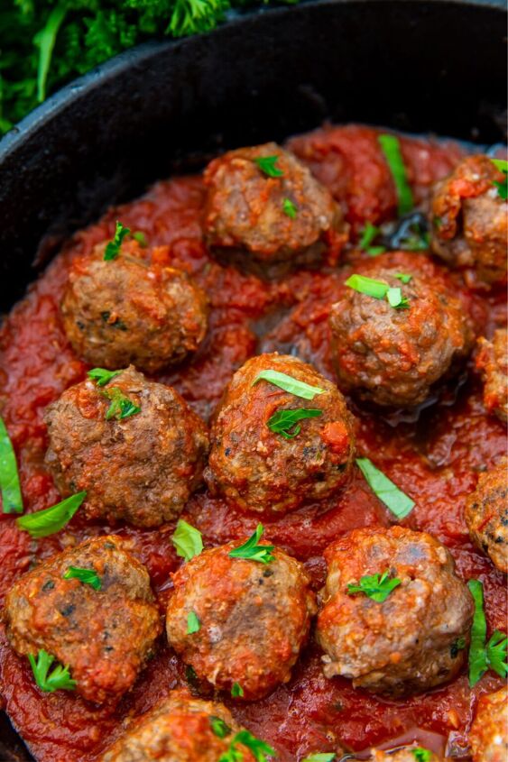 easy keto cast iron meatballs, cooked keto meatballs in a keto spaghetti sauce topped with basil