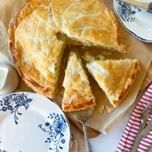homemade spanakopita recipe, A pie is sitting on a plate with a slice taken out