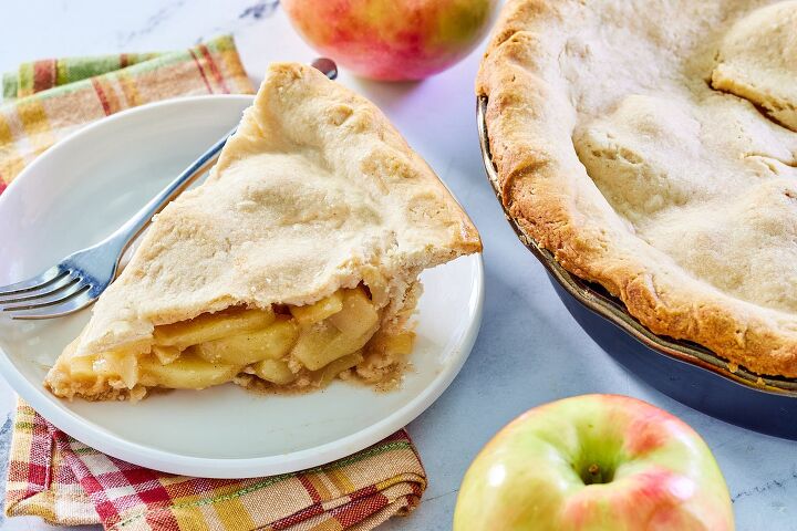 great grandma s apple pie, Piece of grandma s deep dish apple pie next to a couple of fresh apples and the rest of the pie