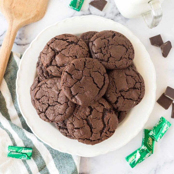 chocolate mint cookies, White plate piled high with chocolate mint cookies showing crackly exterior surrounded by Andes mints candies