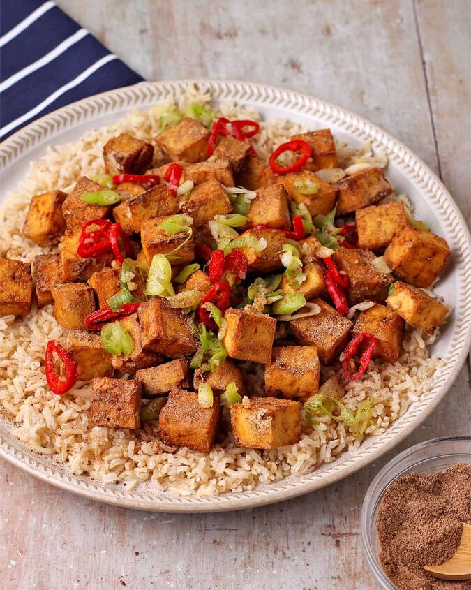 crispy salt and pepper tofu air fryer or baked, Crispy salt and pepper tofu on a plate with brown rice and cooked green onions and sliced red chili