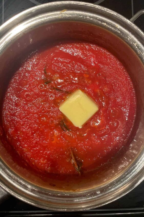 homemade gnudi with tomato sauce, tomato sauce simmering in a saucepan