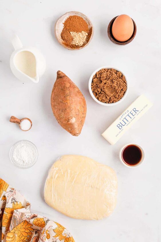 southern sweet potato pie recipe, Ingredients for Sweet potato pie laid out on a white background a sour cream pie crust sweet potato salted butter dark brown sugar eggs heavy cream spices baking powder vanilla extract