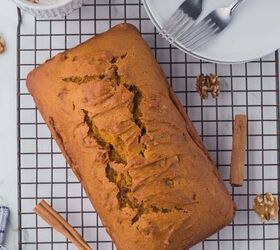 moist pumpkin bread, A loaf of pumpkin bread on a wire rack with cinnamon sticks scattered around and a mug of coffee and stack of plates and forks on the side
