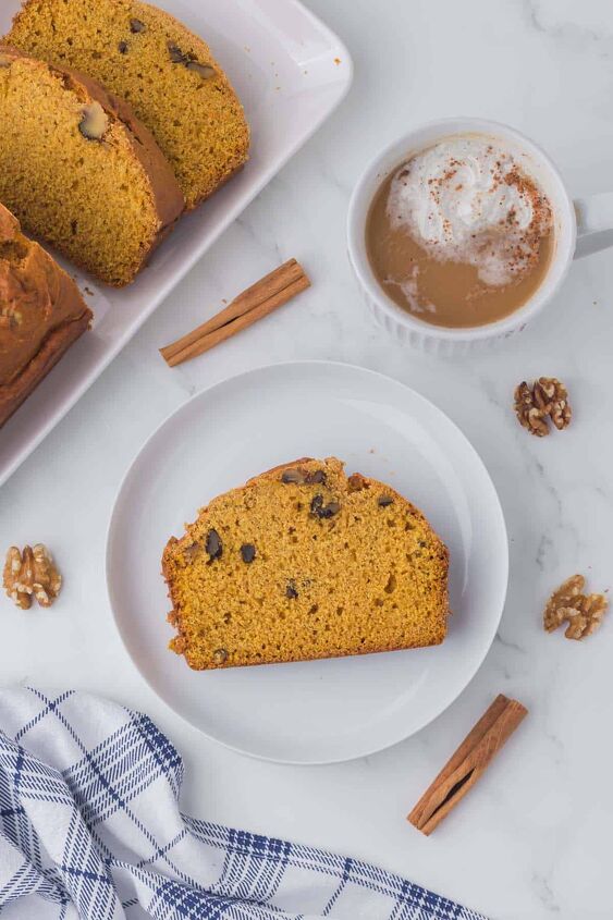 moist pumpkin bread, A piece of pumpkin loaf on a white plate with cinnamon sticks and a mug of coffee on the side