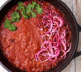 creamy rajma masala vegan kidney bean curry, Baked kidney bean curry in a cast iron pot with sliced red onions and cilantro on top