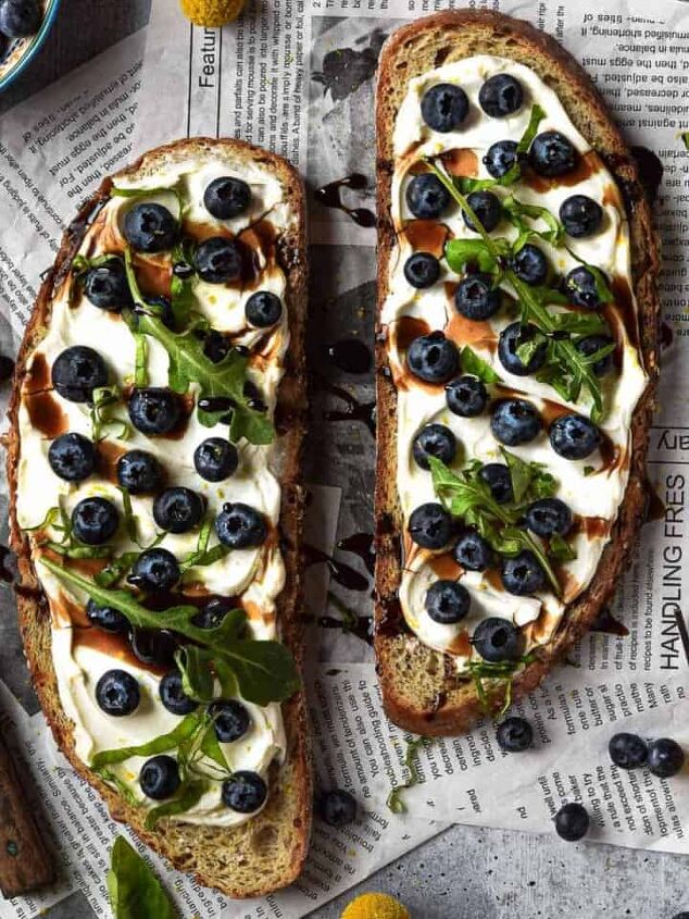 cream cheese avocado toast, Overhead view of blueberry toast on newspaper with yellow flowers around it