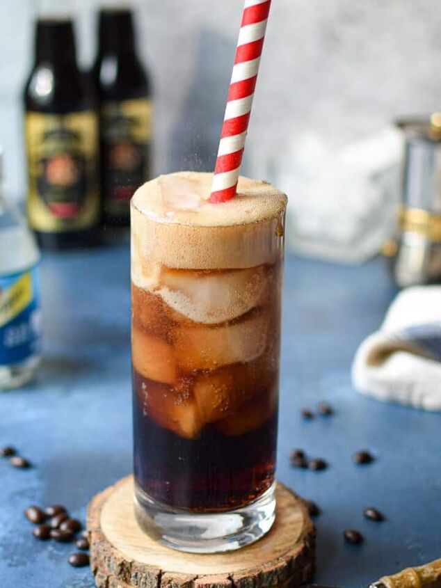 decadent malted milk hot chocolate, Espresso soda in a glass with a red straw on top of a blue surface