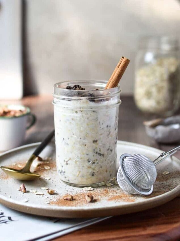 goat cheese scrambled eggs, Eye level view of overnight oats in a jar on a wood surface with the Sunday paper showing