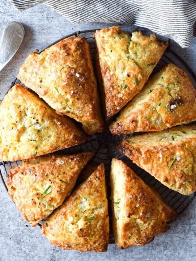 goat cheese scrambled eggs, Overhead view of smoked gouda and chive scones cut in eight triangles on a concrete gray background