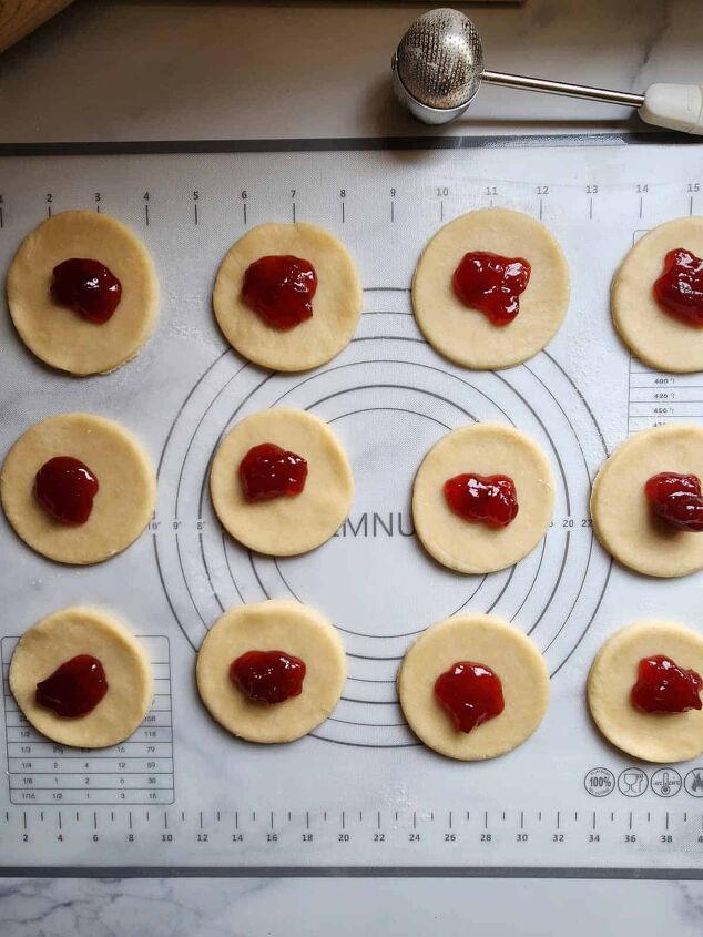 strawberry mini pies with rose glaze, Pie dough cut in circles with strawberry jam placed in the middle