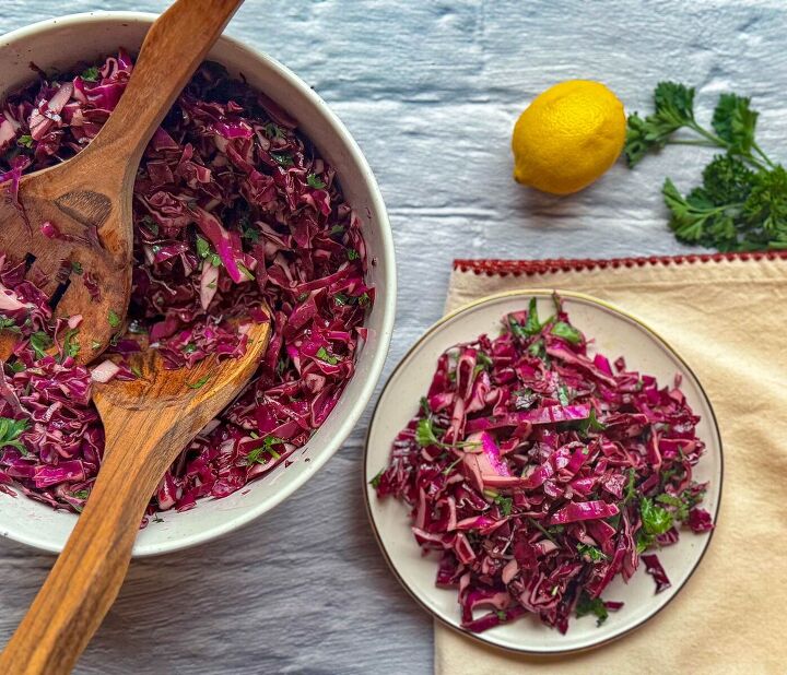 fresh easy turkish red cabbage salad recipe, turkish red cabbage salad in large bowl with wood tongs next to salad plate with a serving lemon and parsley above