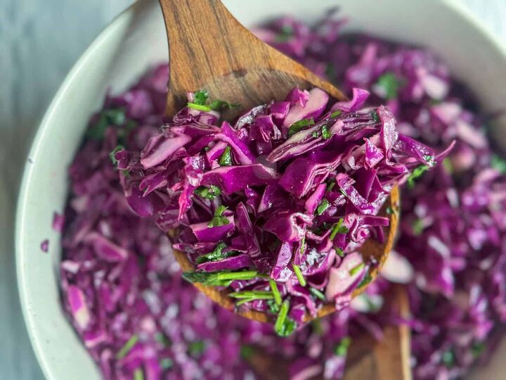 fresh easy turkish red cabbage salad recipe, close up of turkish red cabbage salad on serving spoon with bowl in the background
