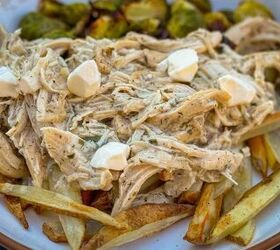 ultimate ranch chicken poutine with homemade fries, plate of chicken poutine on fries with cheese curds on top and brussels sprouts in the background