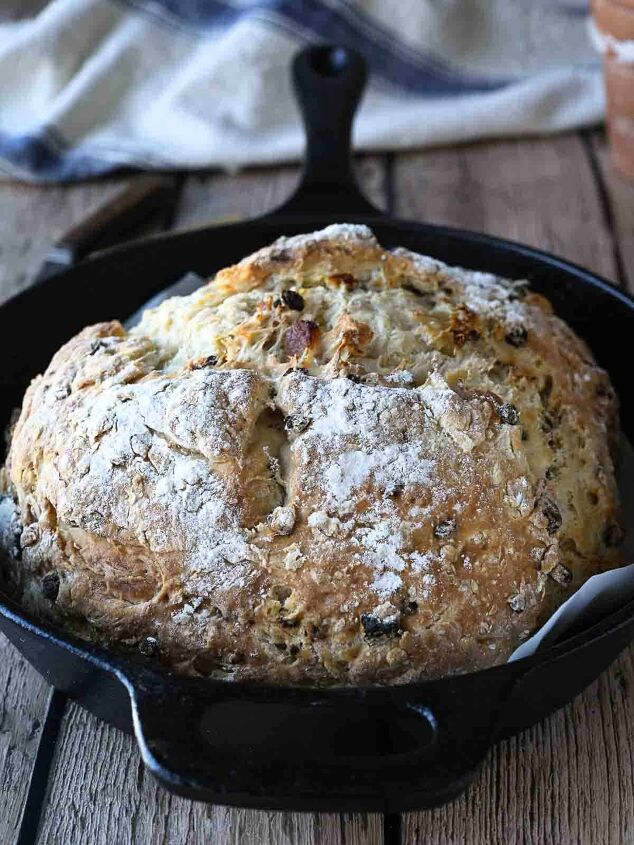 irish soda bread with currants and apricots, Irish soda bread in a cast iron skillet on a wood surface