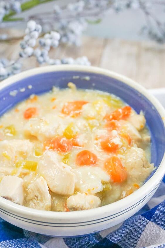 slow cooker chicken and dumplings, Slow Cooker Chicken and Dumplings in a white and blue bowl next to a white and blue checkered cloth