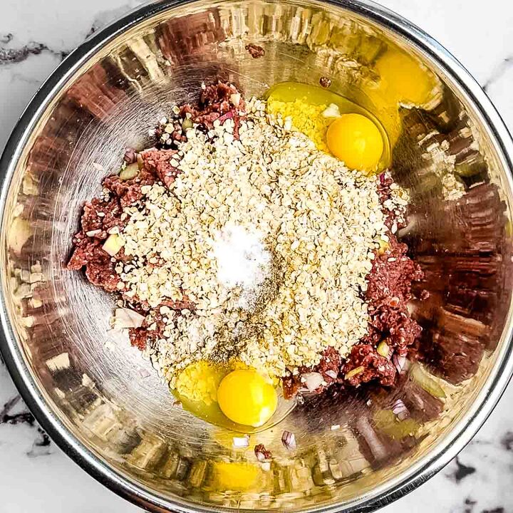 meatloaf recipe with bbq sauce and brown sugar, Oatmeal eggs and seasoning added to the meatloaf mixture in a large stainless steel bowl