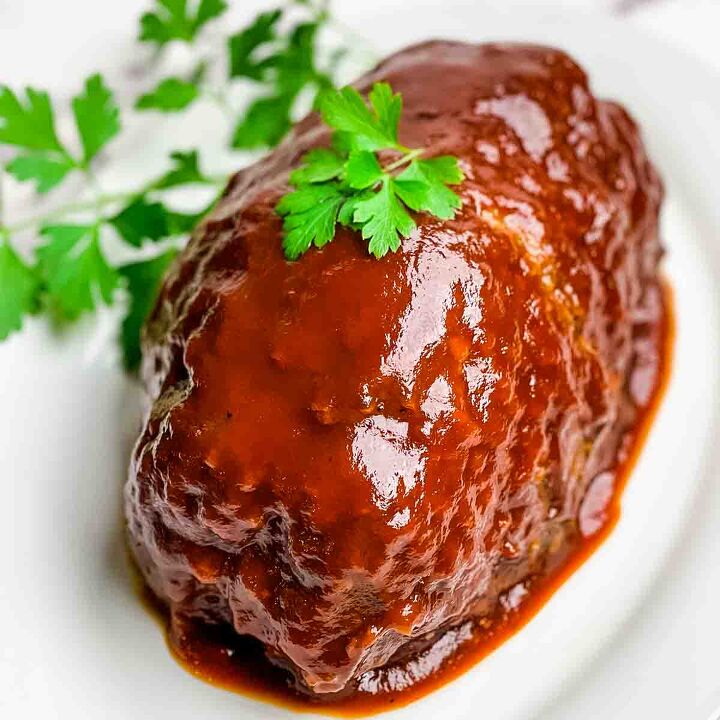 meatloaf recipe with bbq sauce and brown sugar, The cooked meatloaf with extra glaze spooned over the top topped with a sprig of parsley for garnish