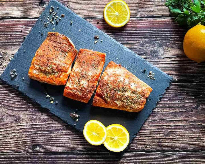 best smoked salmon on pellet grill recipe, Tender and juicy salmon fillets on a serving plate with lemon wheels in the background