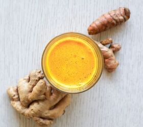 lemon ginger turmeric shot, glass filled with lemon ginger turmeric shot with ginger and turmeric roots from above