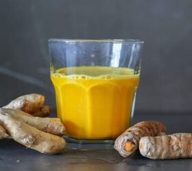 lemon ginger turmeric shot, glass filled with lemon ginger turmeric shot with ginger and turmeric roots