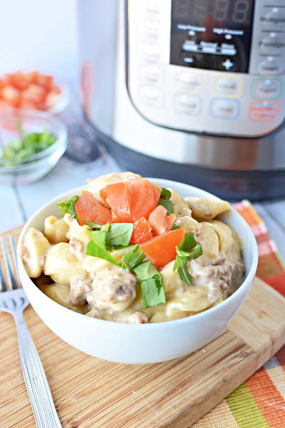 instant pot cheeseburger mac and cheese recipe, white bowl filled with cheesy shells ground beef and chopped tomatoes