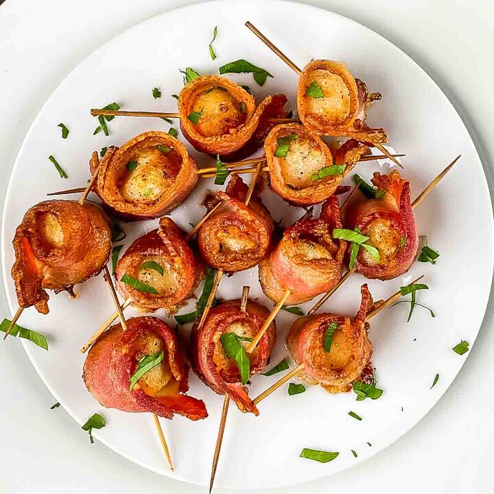 air fryer bacon wrapped scallops, Air fried scallops wrapped in bacon on a white plate garnished with fresh parsley
