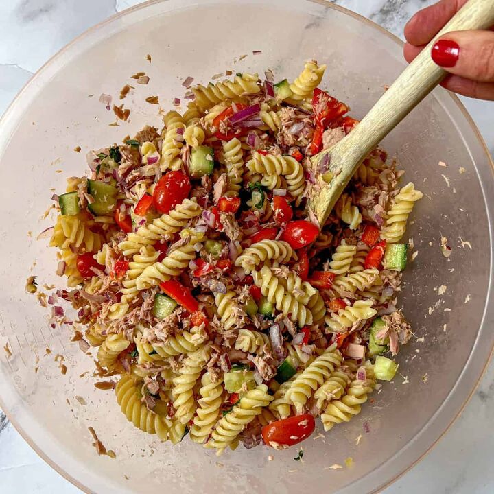 healthy tuna pasta salad no mayo, Tuna pasta salad in a large bowl being stirred with a wooden spoon