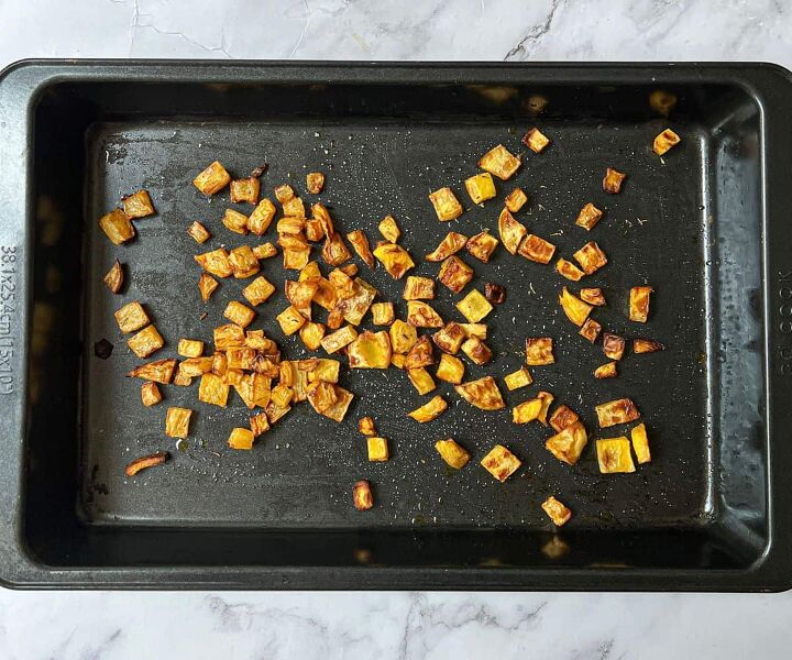roasted swede oven and air fryer, Roasted cubes of swede on a black rectangular baking tray