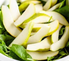 spinach cranberry salad recipe, Pears added on top of green leaves in a bowl