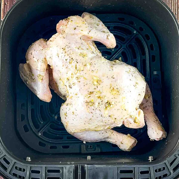 air fryer whole roast chicken with lemon and garlic, The chicken breast side down in the air fryer basket