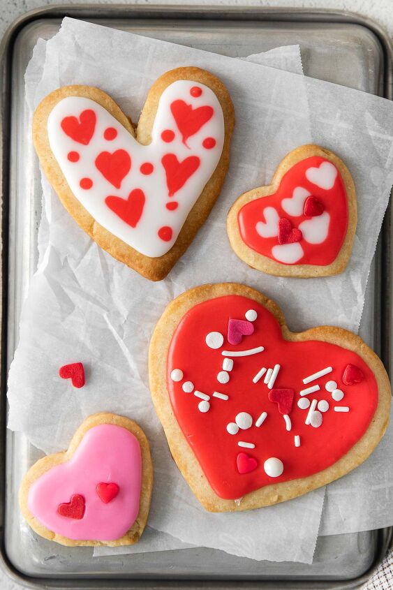 iced shortbread cookies, closeup of four pink and red iced shortbread cookies with valentine themed sprinkles